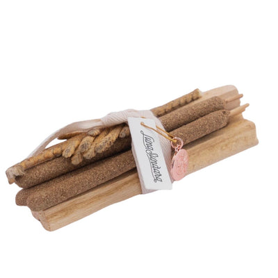 a bundle of palo santo sticks, palo santo incense and palma dulce tied with a linen tie and a branded tag.