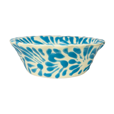 side view of a aqua and white Puebla design ceramic bowl with a scalloped edge