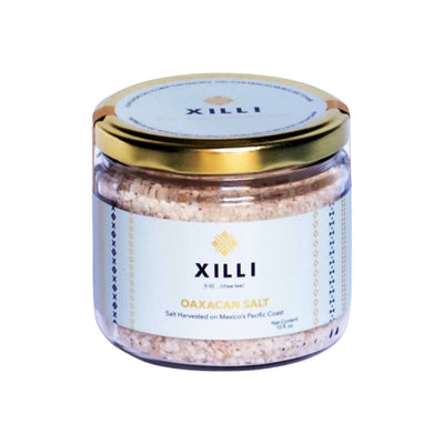 Clear 10 oz jar of Oaxacan salt with a baby blue branded label and gold lid