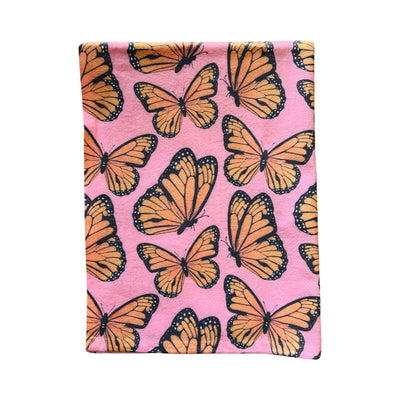 pink towel with a monarch design folded in quarters