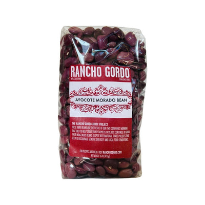 Clear single 16 oz bag of Ayocate morado (purple) beans with red and white branded labeling.