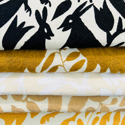 Collection photo for our "Textiles" collection. Image is folded stack of our otomi table runners available in different colors