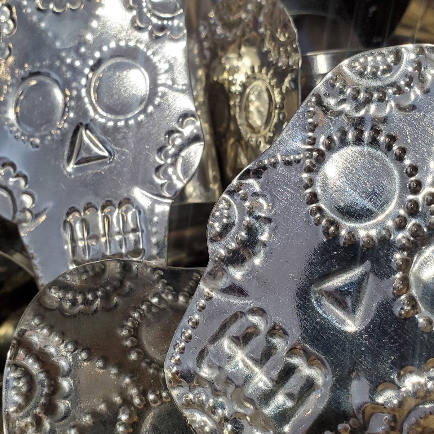 Collection photo for our "Shop By Color: Silver" collection. Image contains a pile of our silver skull napkin rings