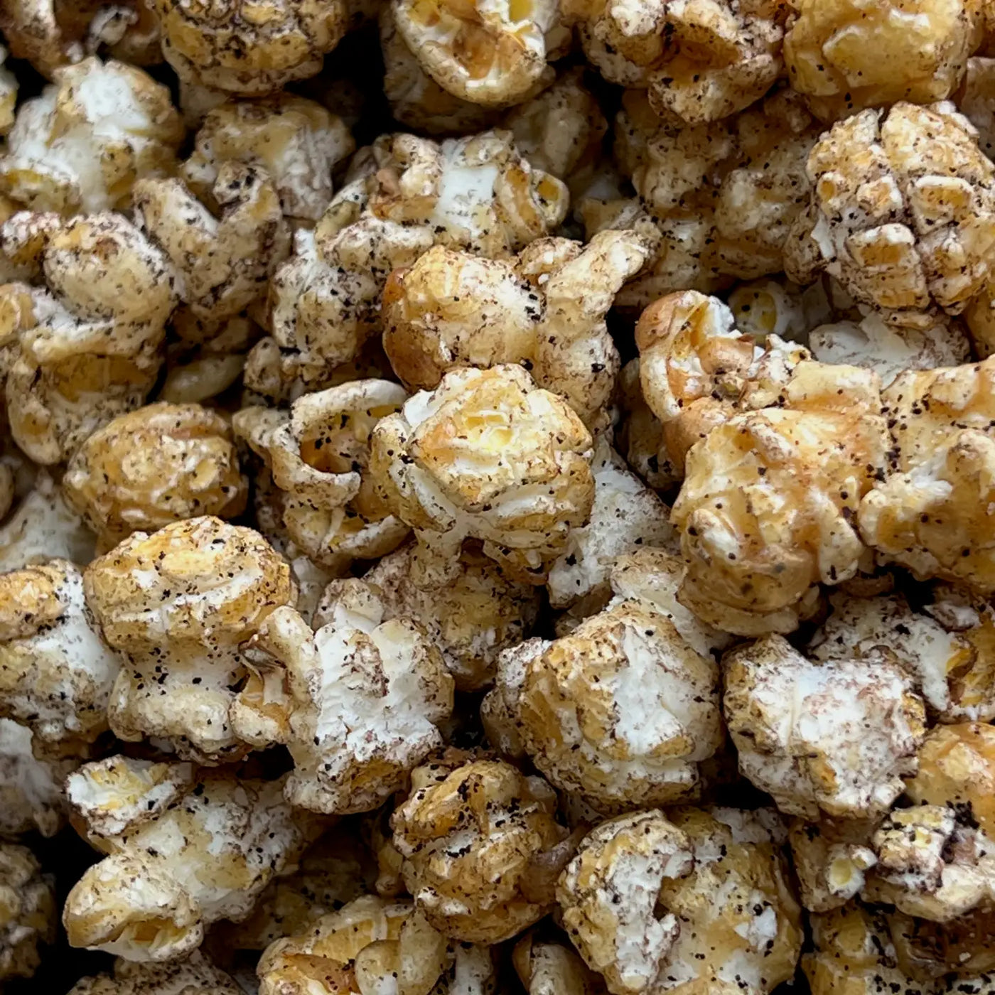 close up view of popcorn with caramel and speckles of espresso powder