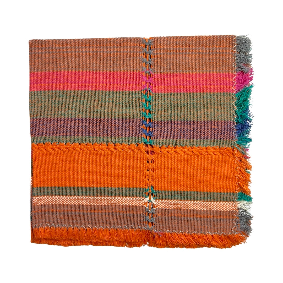 Handwoven napkin with stripes of orange, pink, bue, gray and natural colors folded in quarters