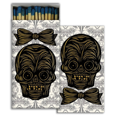 set of match boxes with a design on each one of a skeleton head, one female and one male, featuring blue tip matches.