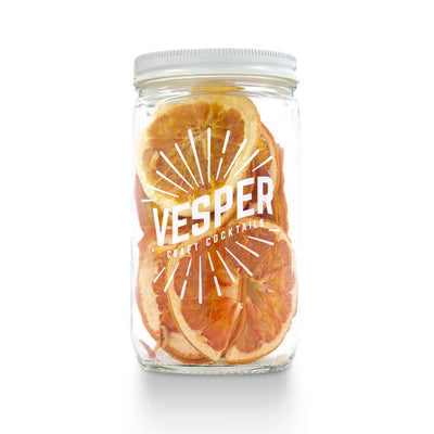 clear jar with a white lid of dehydrated grapefruit and orange slices featuring the brand VESPER in white lettering.