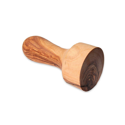 olive wood coffee tamper laying on its side