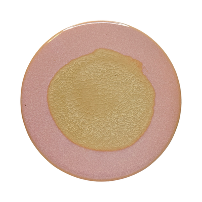 pink round stoneware trivet with two-tone reactive glaze, showing slight variations in finish.
