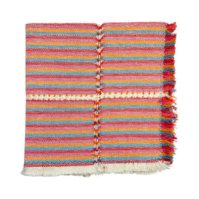 red, turquoise, orange, and natural striped handwoven napkin folded in quarters