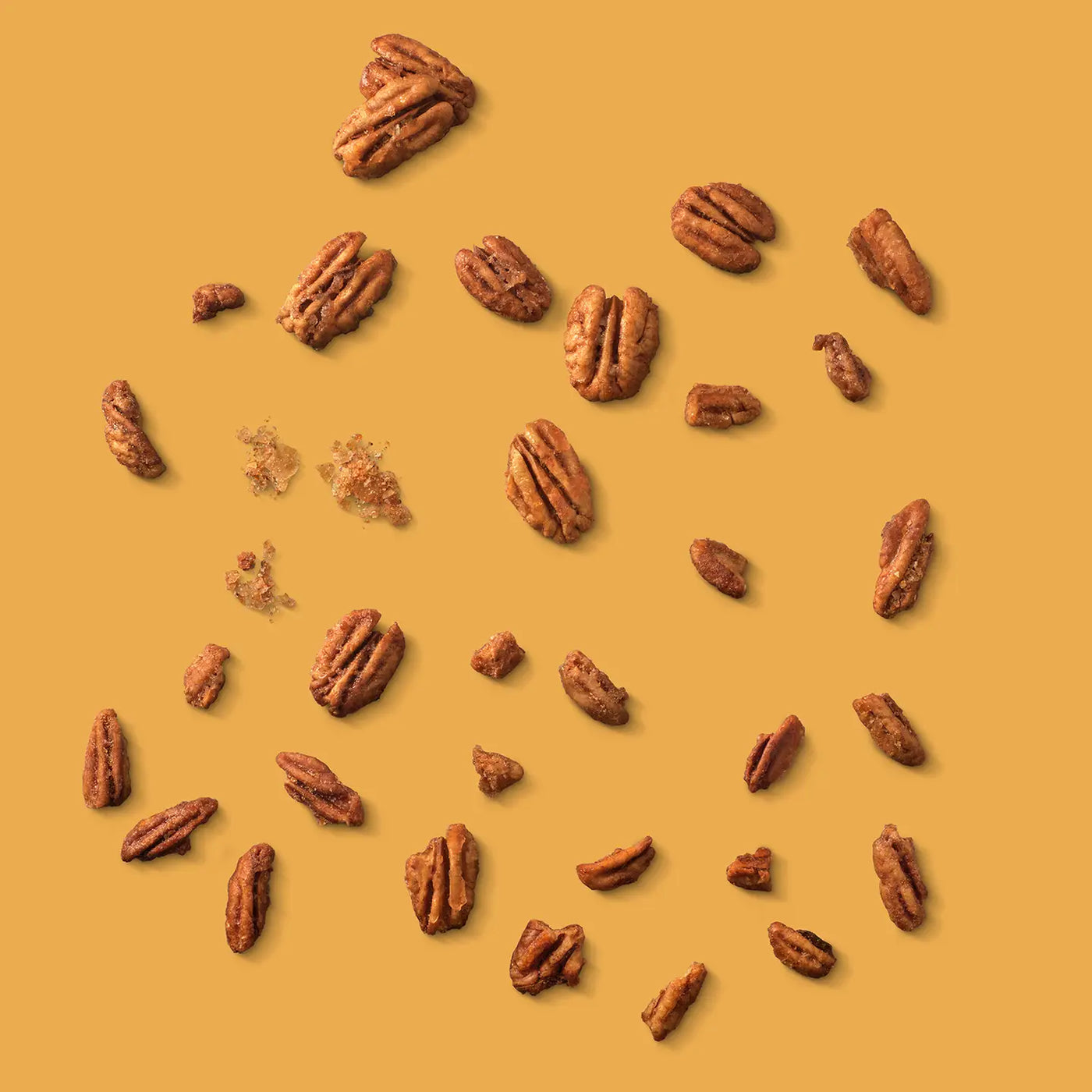 Pecans scattered on a yellow background