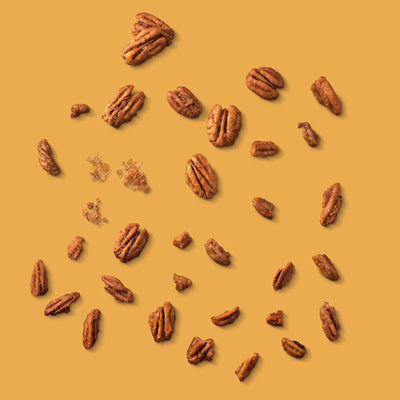 Pecans scattered on a yellow background