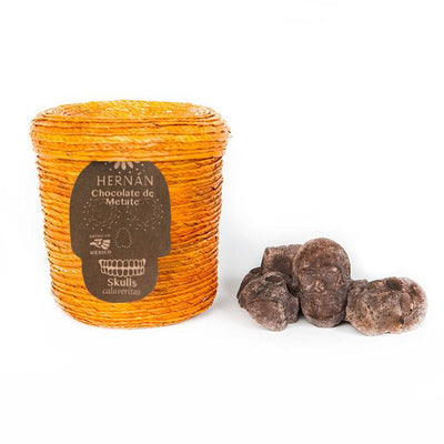 Marigold colored palm basket with a lid and skull shaped chocolates pieces.