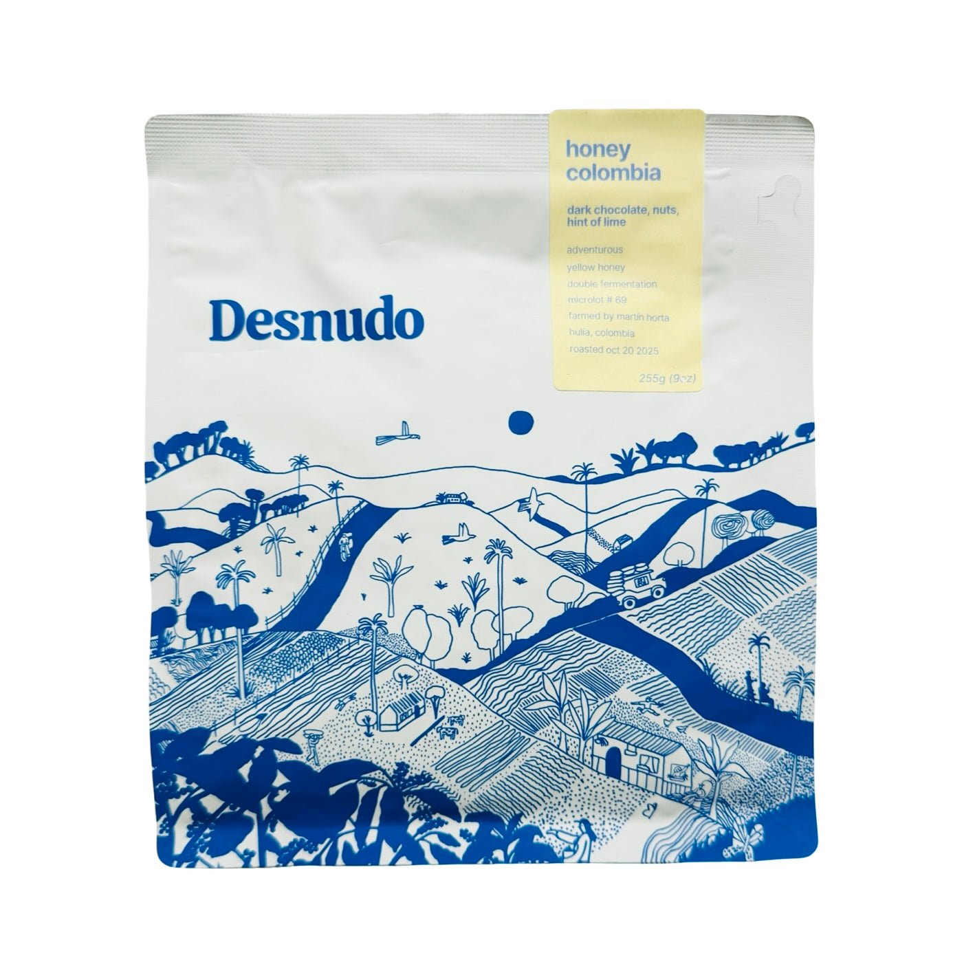 9 oz white Bag of Honey Colombia Coffee featuring blue illustrated Colombian landscape.