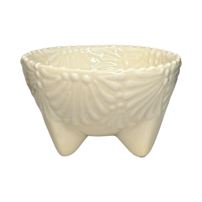 Handcrafted ceramic molcajete-style bowl with a white floral design on a cream background and three short legs.