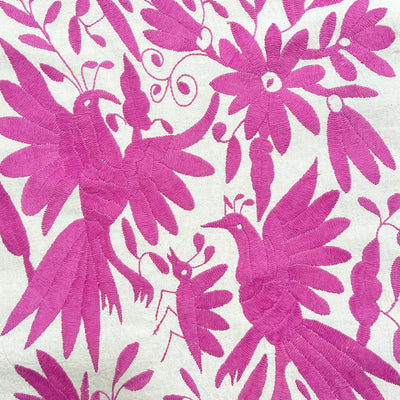 enhanced view of magenta floral and fauna scenery detail embroidered on off white table runner