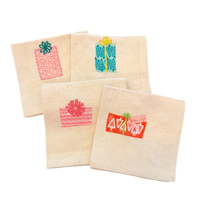 Set of four cotton cocktail napkins, each embroidered with a different colorful Christmas gift design.