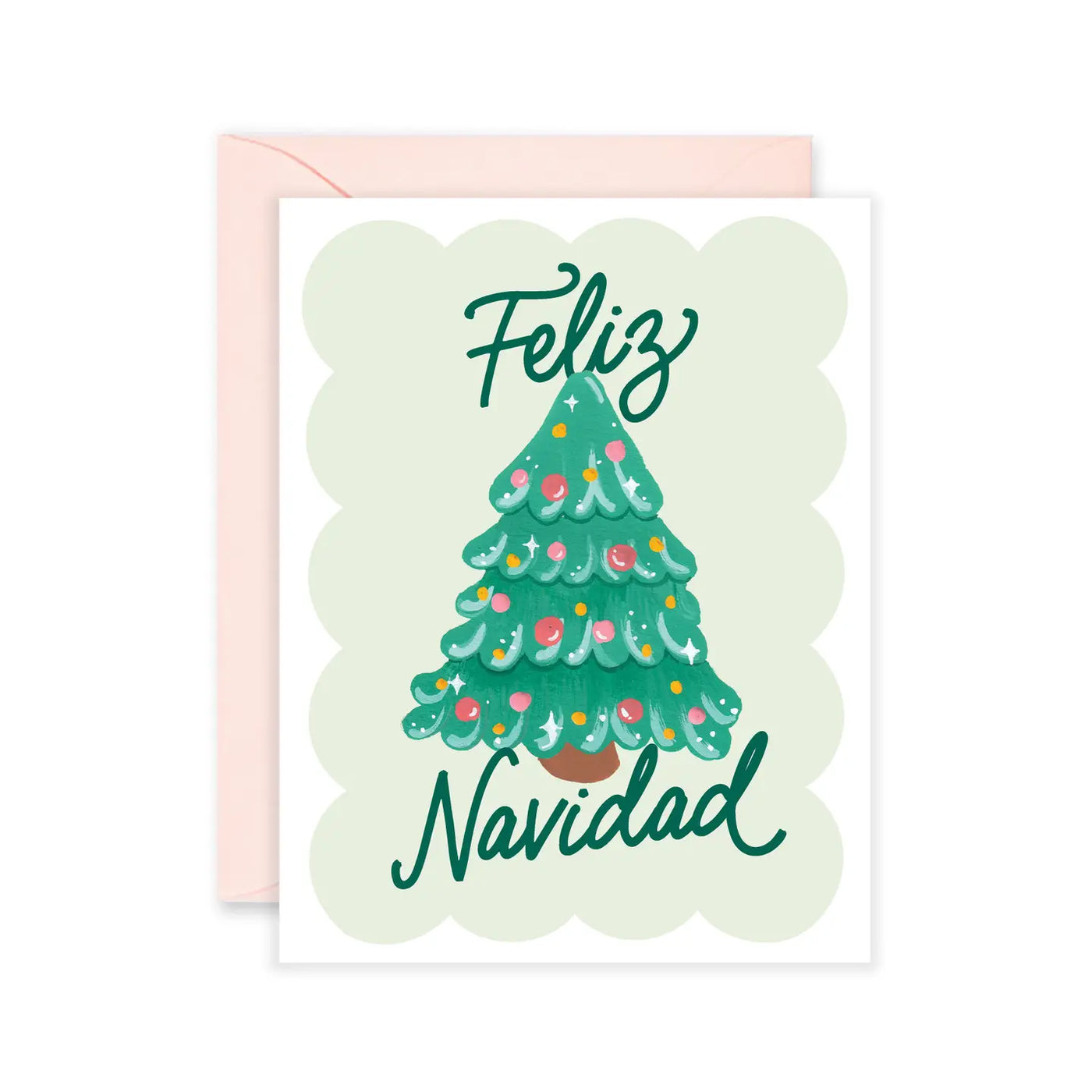 Greeting card with an illustrated Christmas tree and the words “Feliz Navidad,” photographed with a light pink envelope behind it.