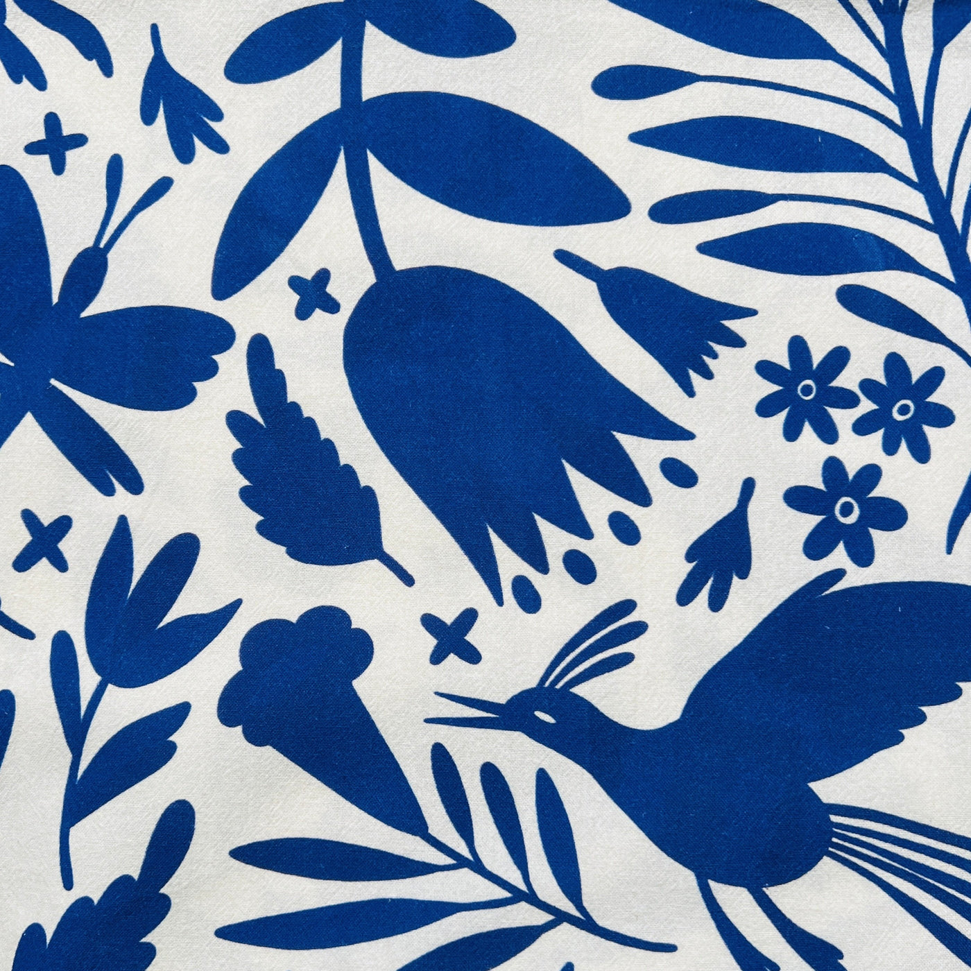 close up view of a cream towel with a blue otomi design