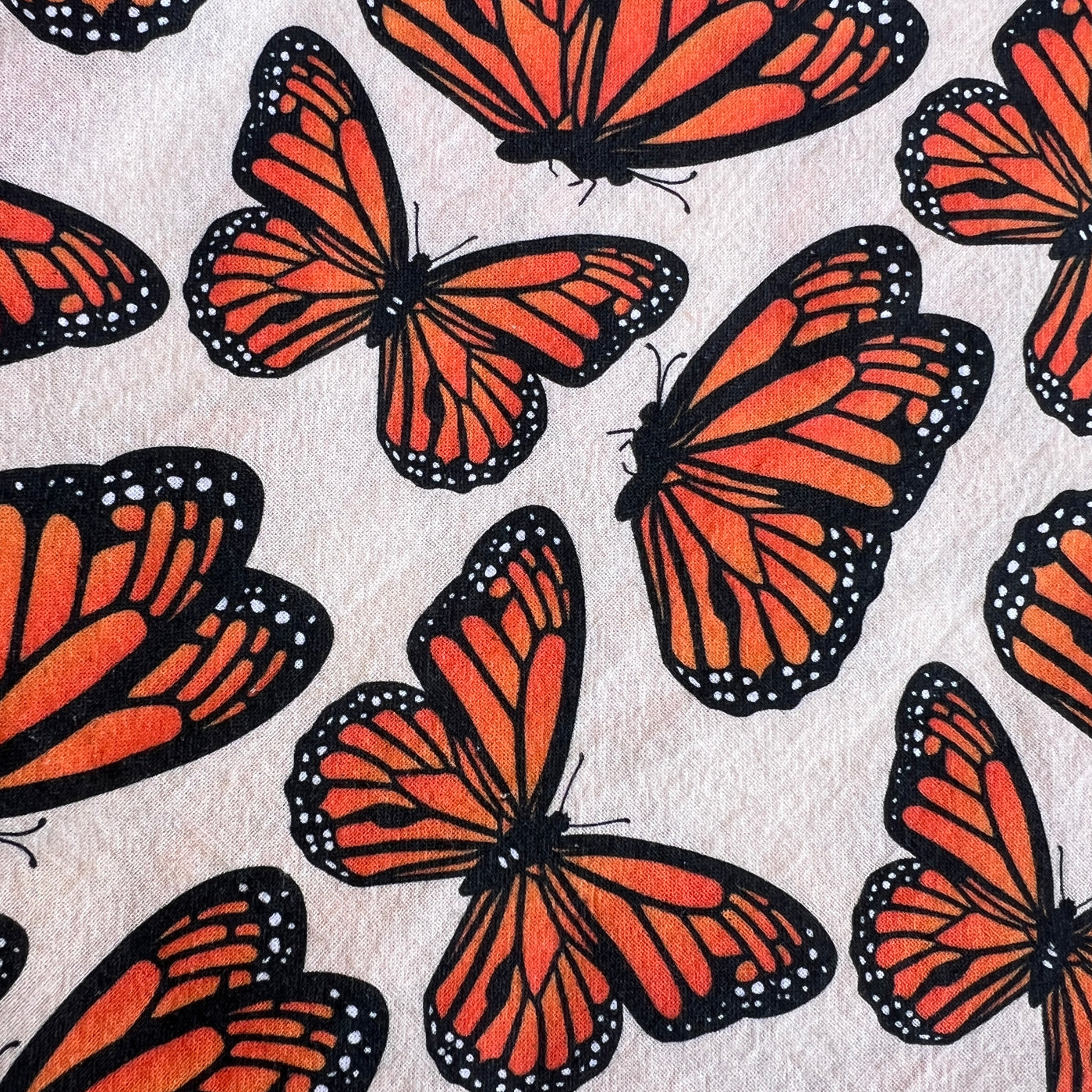 close up of a light beige towel with a monarch butterfly pattern