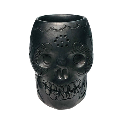 front view of a black clay shot glass with a sugar and floral design.