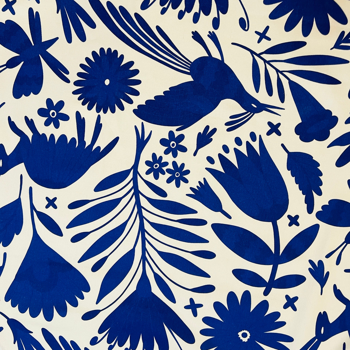 close up view of a Apron featuring a blue Mexican otomi design with blue neck and waist ties.