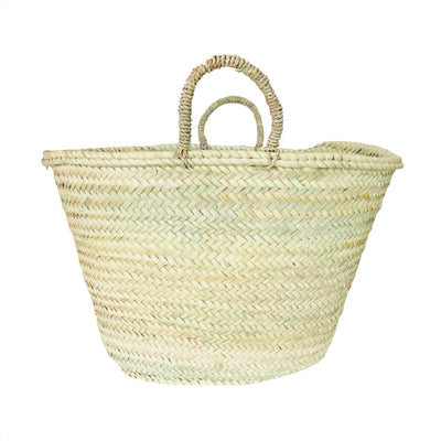 A handwoven straw market basket made from natural palm leaves, featuring a wide, open-top design and sturdy braided handles. 