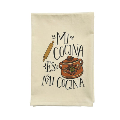 natural floursack towel folded in quarters with an image of a rolling pin and a Mexican bean pot with the phrase Mi Cocina Es Mi Cocina in black lettering.