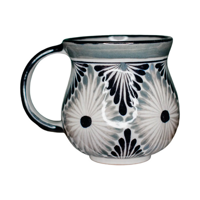 Handpainted ceramic mug with a black and grey floral-inspired design on a white background, featuring a rounded body and handle.