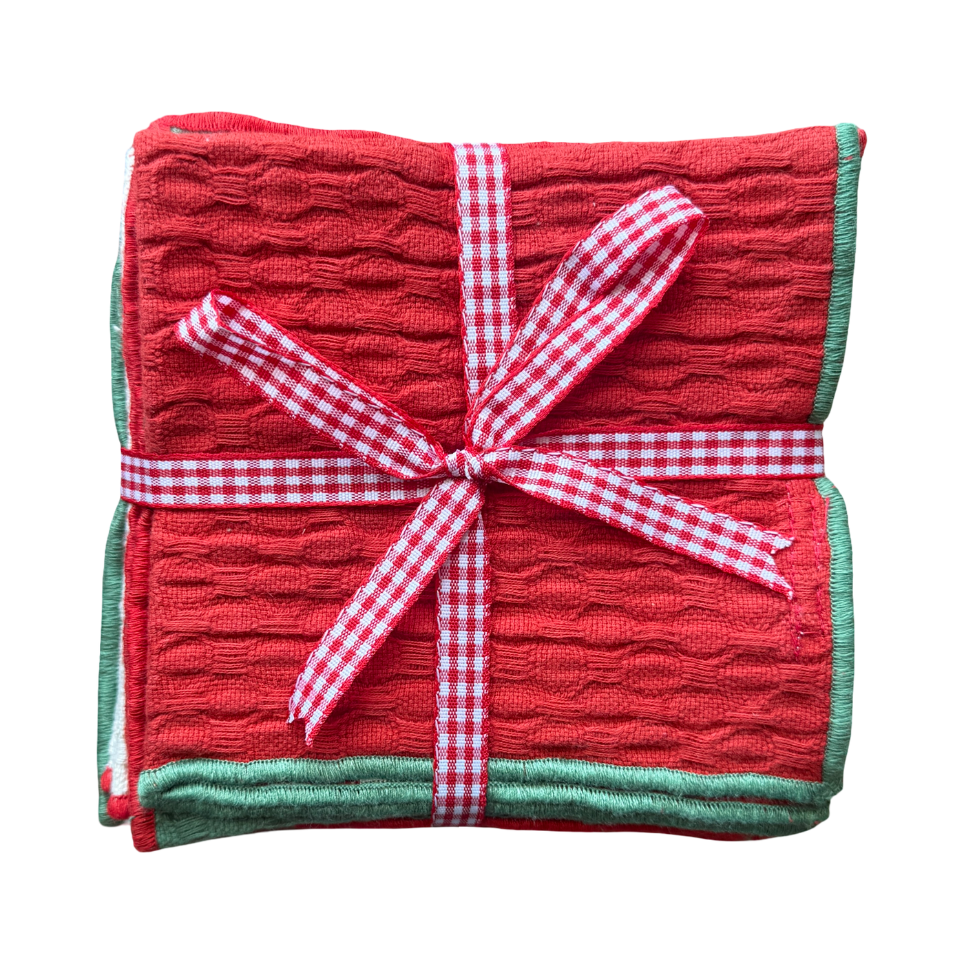 set of 4 dish cloths in red, green and beige folded in quarters and tied with a white and red plaid ribbon.