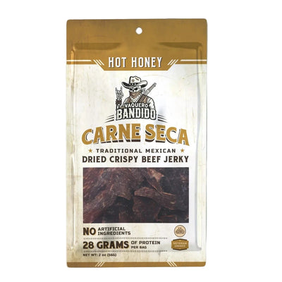 Front of Vaquero Bandido “Hot Honey Carne Seca” pouch showing window with dried beef strips and label reading “Traditional Mexican Dried Crispy Beef Jerky,” “No Artificial Ingredients,” “28 Grams of Protein per Bag,” net wt. 2 oz.
