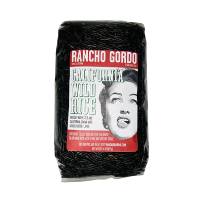 16 oz clear bag of California Wild Rice with a white and maroon branded label featuring an image of a woman licking her lips.