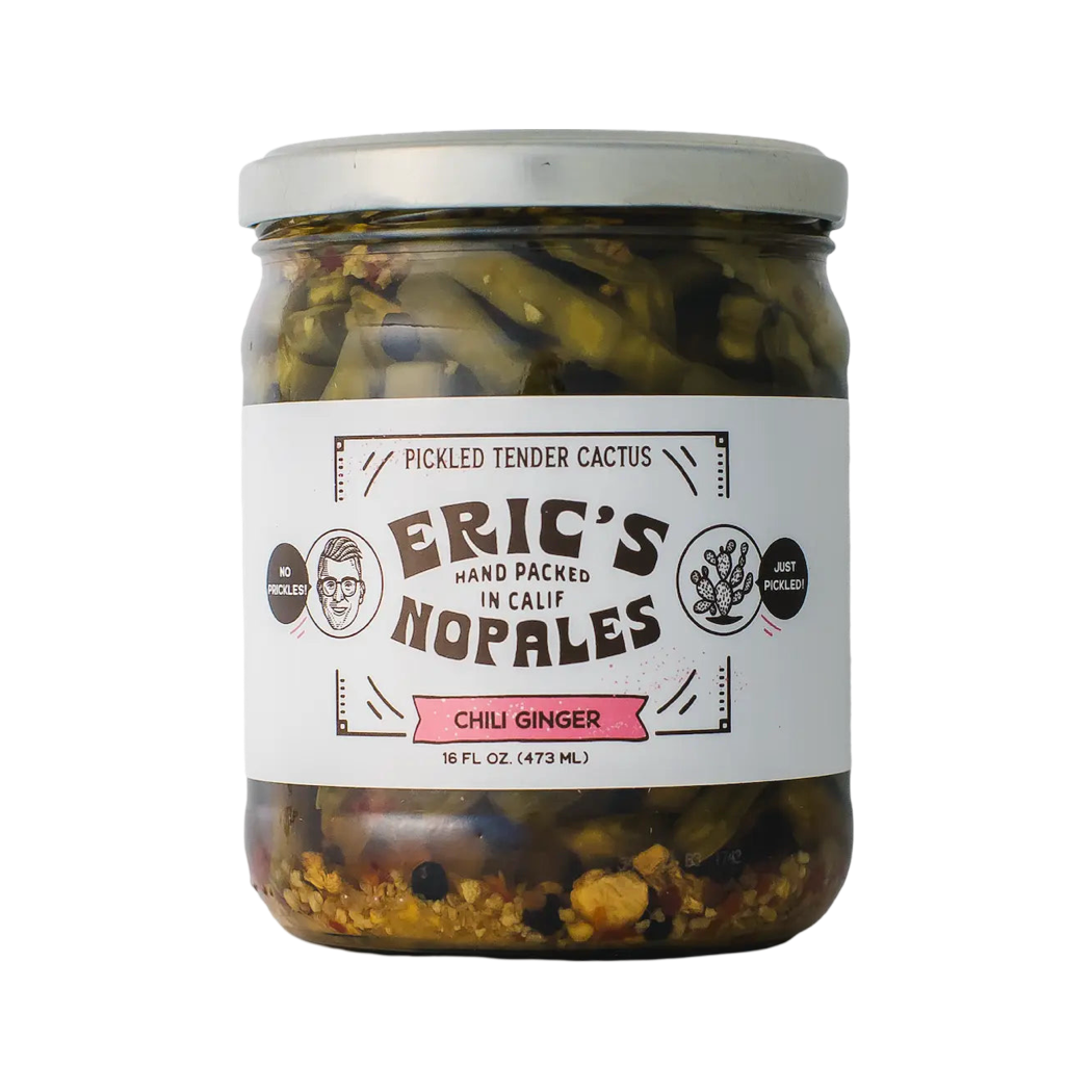 16 fl oz clear ar of Eric's Nopales featuring pickled tender cactus in chili ginger flavor. The label reads "Hand Packed in Calif" with playful graphics, including a face icon with the phrase "No Prickles!" and a cactus illustration labeled "Just Pickled!"