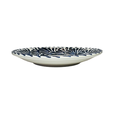 Side view of a blue and white Puebla talavera round plate