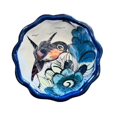 round dish with a blue scalloped edge and features a bird and flower design.