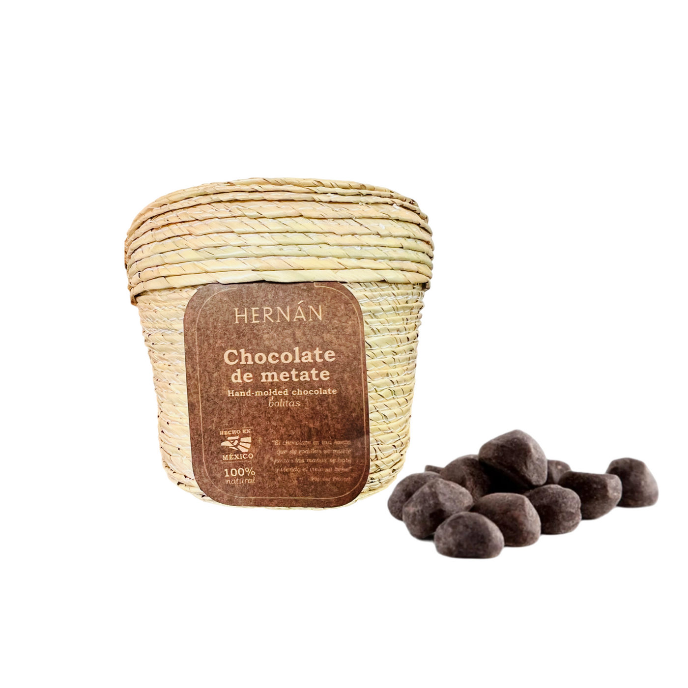 Natural palm basket with a brown branded label with some chocolate balls to the side of it.