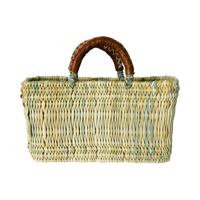 A rectangular woven reed market basket with sturdy leather-wrapped handles.