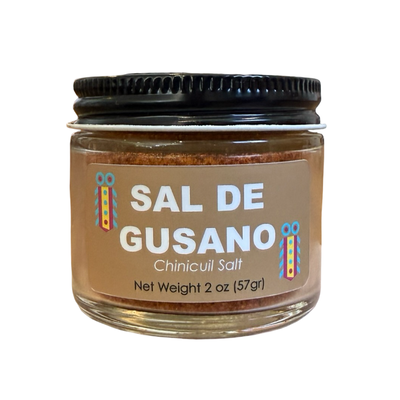 2 oz clear jar of Sal De Gusano - Chinicuil Salt with a black lid and brown branded label.