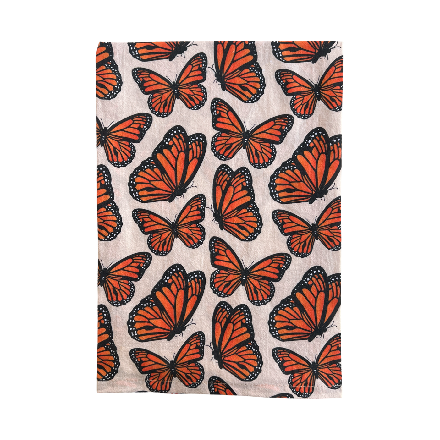 light beige towel with a monarch butterfly pattern folded in half.