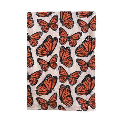 light beige towel with a monarch butterfly pattern folded in half.