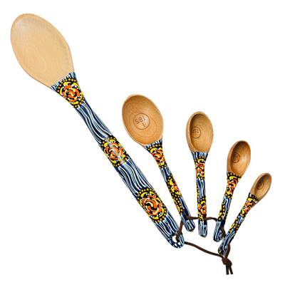 set of wooden measuring spoons and a baking spoon with handpainted handles with a a navy blue and white design featuring a yellow and orange swirl design.