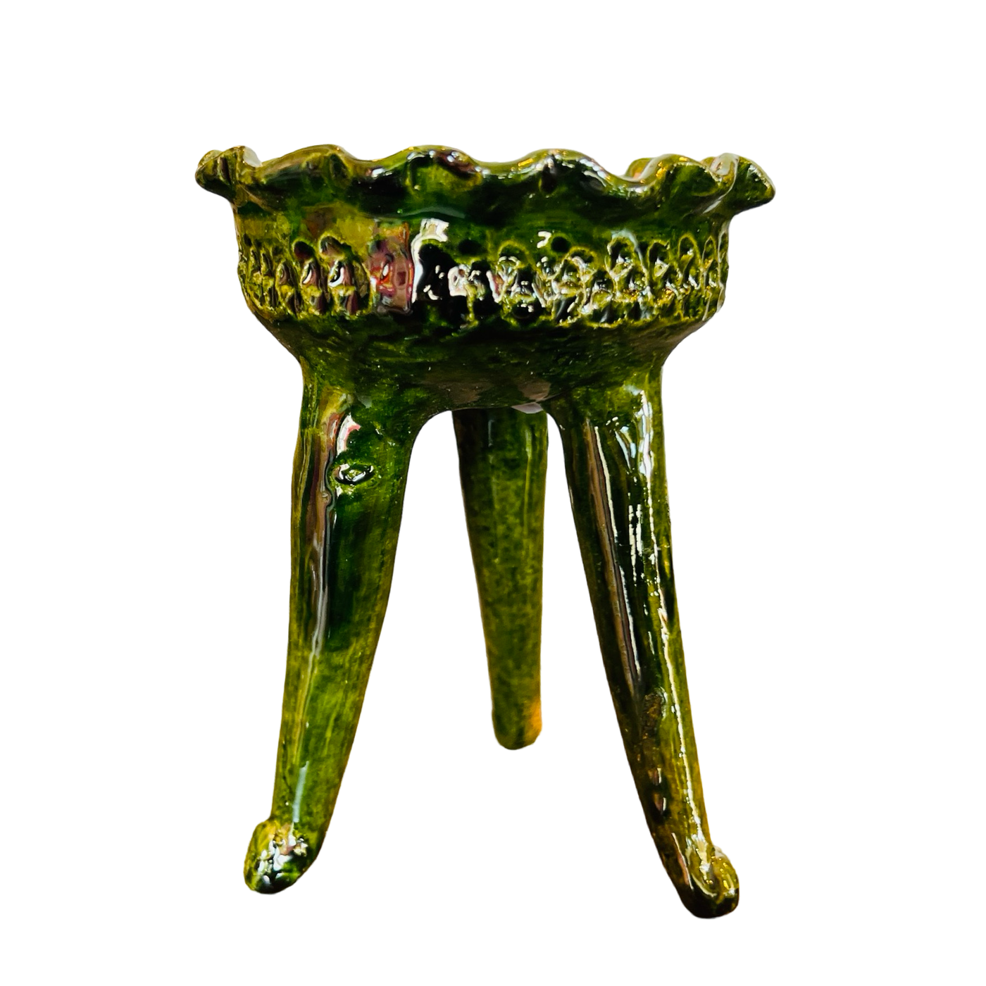 Side view of a three legged copalero, incense holder, with a green glaze.