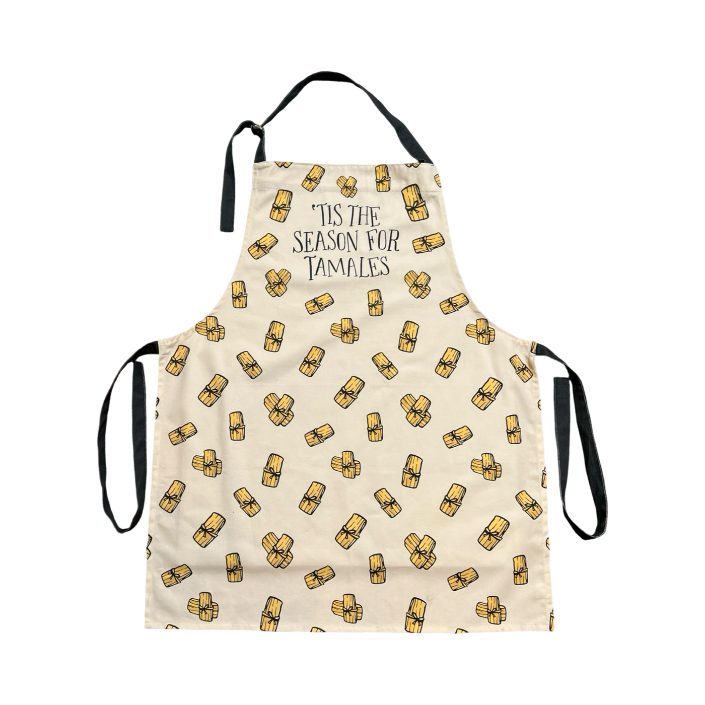 This image features a festive apron with a light beige background and a repeating pattern of tamales. The apron includes the playful text "Tis the Season for Tamales" at the top with black neck and waist ties.