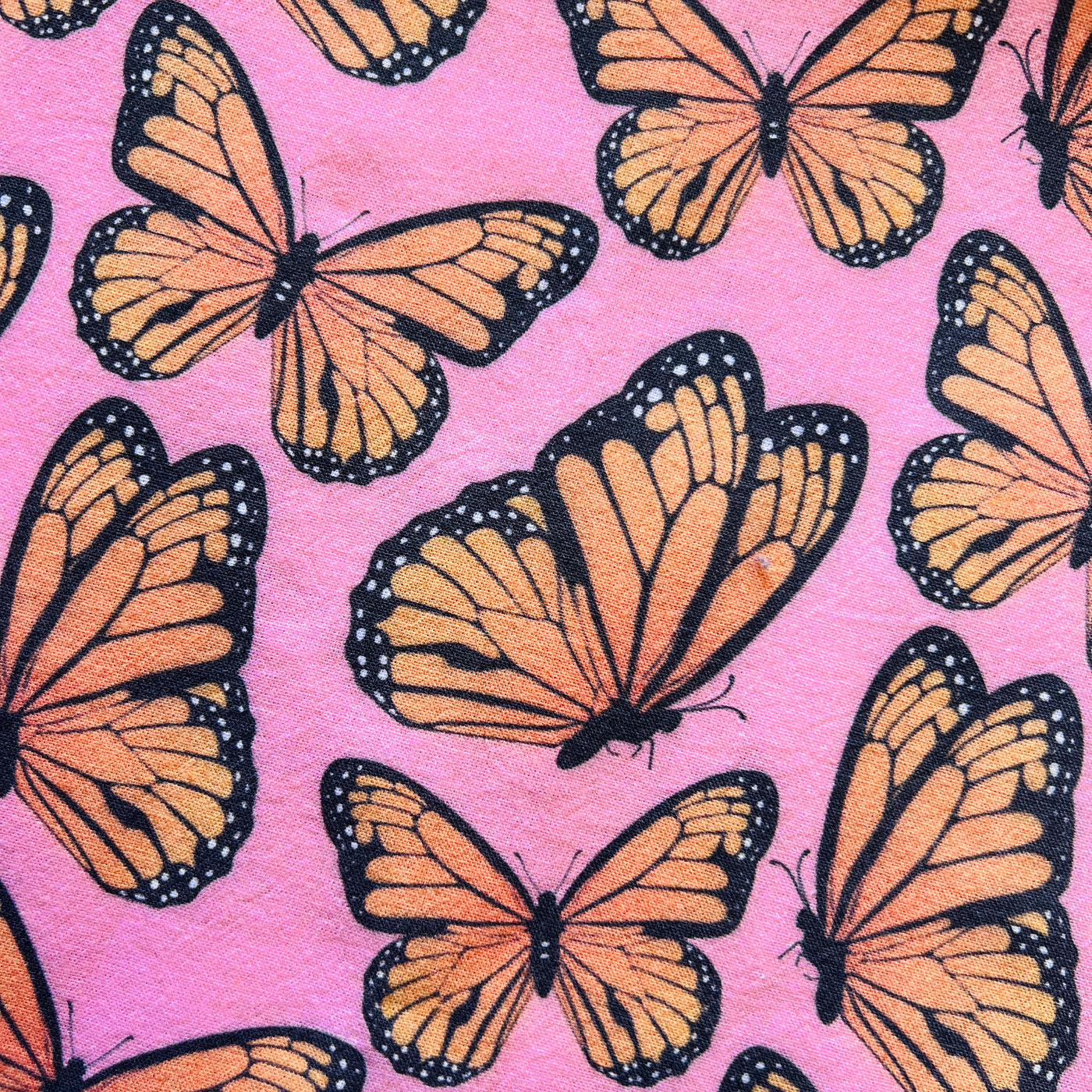 close up view of a pink towel with a monarch design