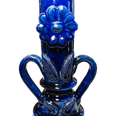 Close up view of the flower detail on blue barro candlestick holder