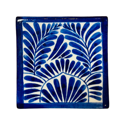 square ceramic coaster with a blue decorative design.