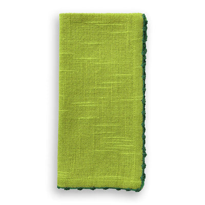 Folded fern green cotton napkin with a hand-knotted green trim along the edge.