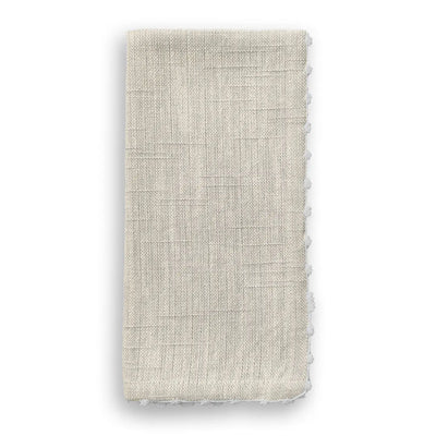 Folded natural cotton napkin with hand-knotted white trim along the edge.