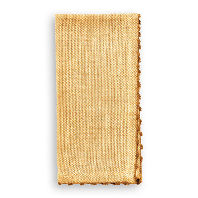 Folded ochre-colored cotton napkin with hand-knotted ochre trim detail along the edge.