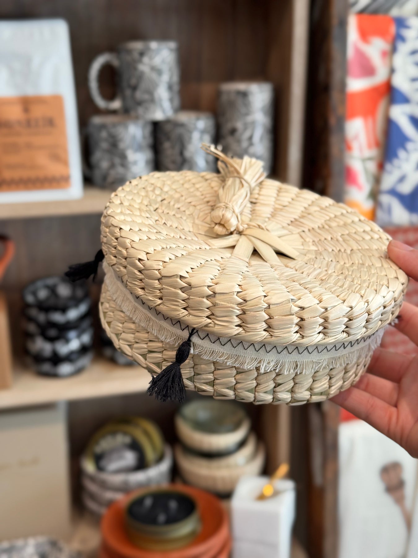 Handheld woven basket with a lid in a store setting
